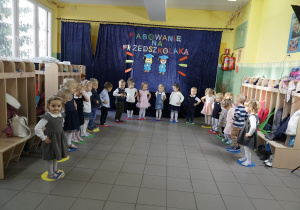 Dzieci stoją i trzymają ręce na biodrach.